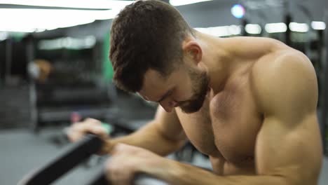 atleta de fitness que entrena los músculos de las manos, disfrutando de una difícil práctica de resistencia en el gimnasio