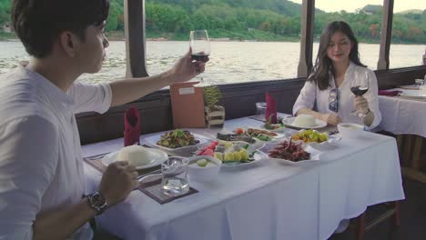 happy couple toasting with wine glasses on boat,slow motion