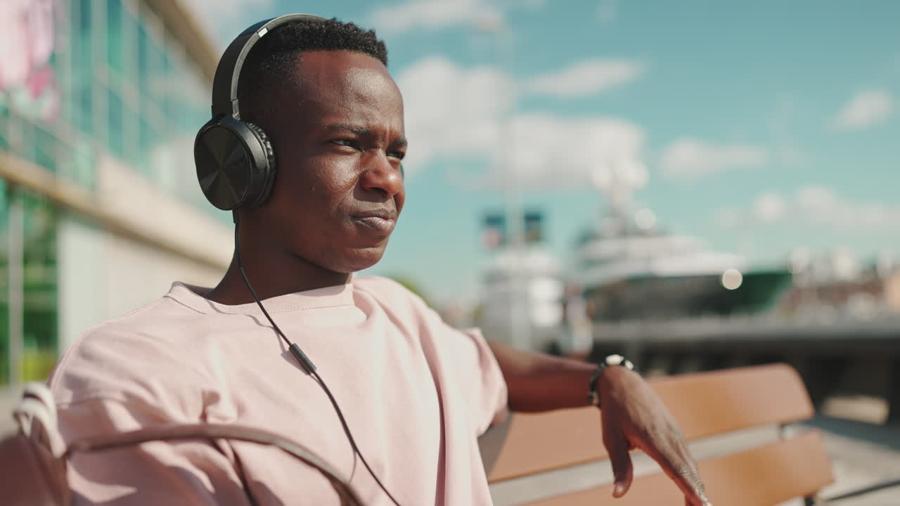 Young Man Listening to Music with Headphones Outdoors