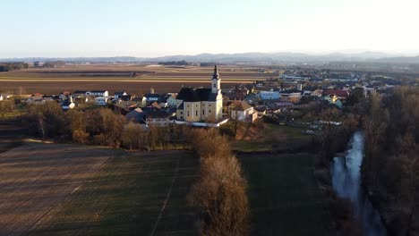 Luftaufnahme-Der-Kirche-In-Einer-Kleinen-Europäischen-Bauernstadt-Bei-Sonnenuntergang