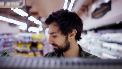 Footage-from-the-shelf---bearded-man-picking-milk-bottle-from-the-shelf