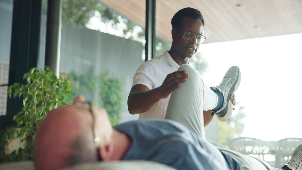 Physical Therapist Stretching Patient's Leg During Rehabilitation Session
