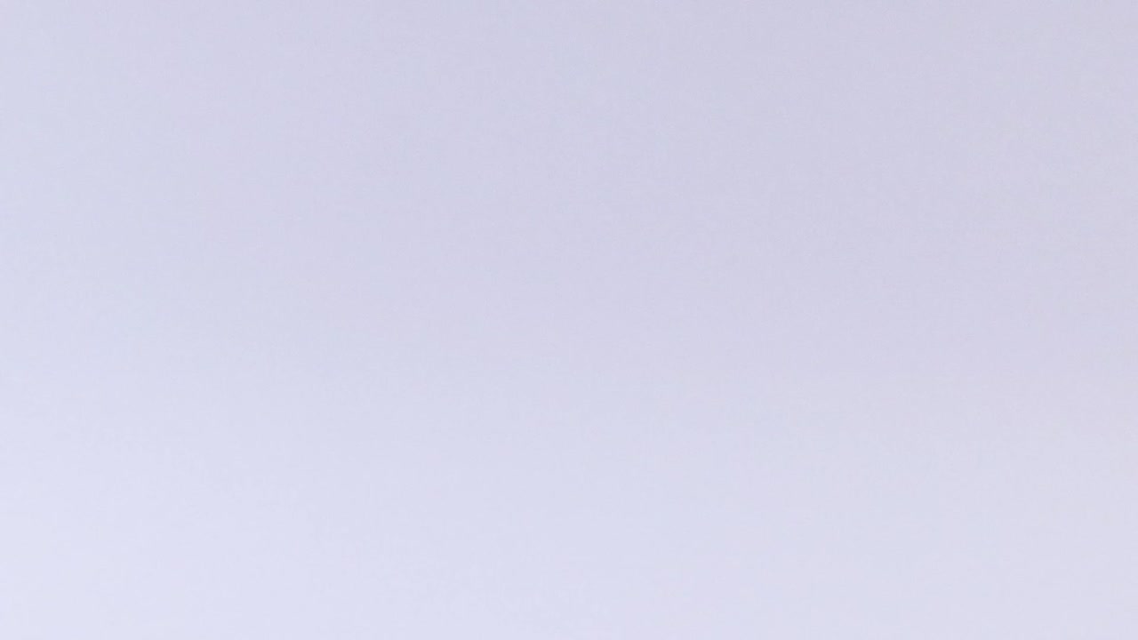 A detailed view of a tennis ball bouncing on a smooth surface, showcasing its motion and shadow.