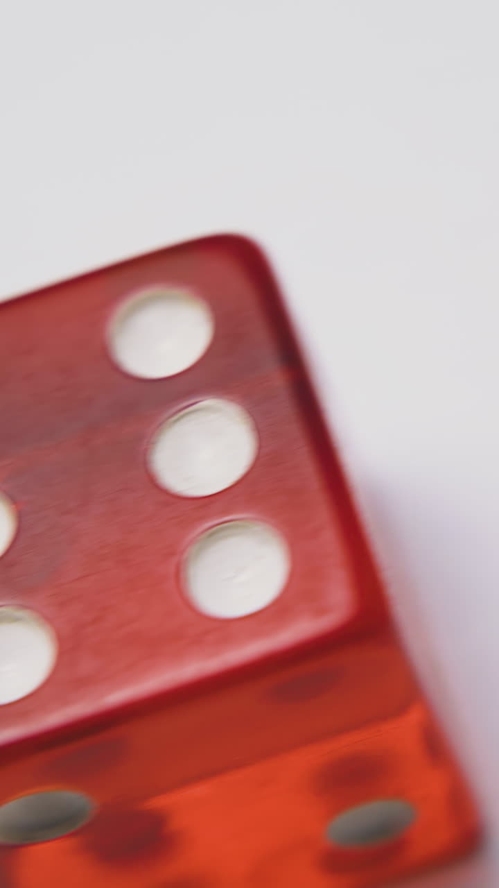 red plastic transparent dices with symbol six on top sides lie on white background extreme close view