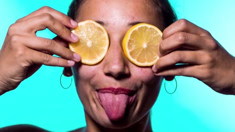 mujer sacando la lengua con rebanadas de limón sobre los ojos