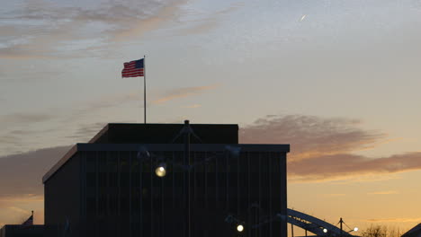 american flag on the rooftop of the headquarter building of modern woodmen of america in rock island, illinois at dawn