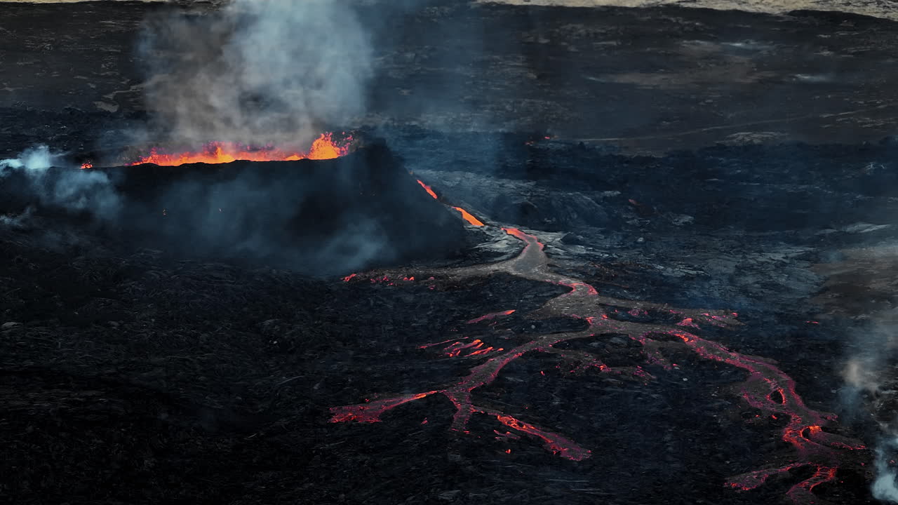 un volcán en erupción, lava derramándose en un entorno devastado, disparos de drones