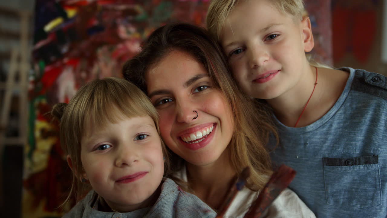 Young woman taking selfie in art school. Happy family looking camera indoors.
