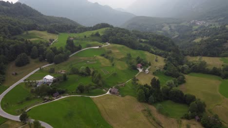 Rolling-green-hills-and-foggy-morning-at-Dreznica-village,-Slovenia-countryside