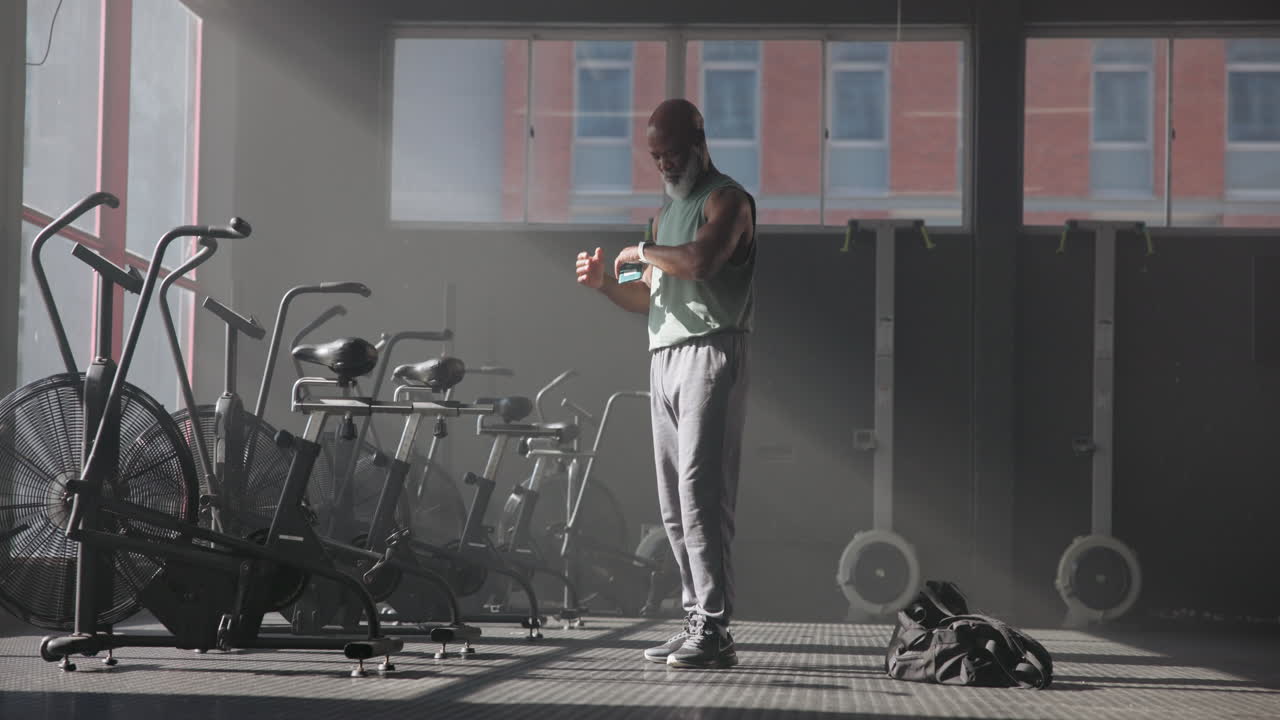 Senior Man Checking Watch in Gym