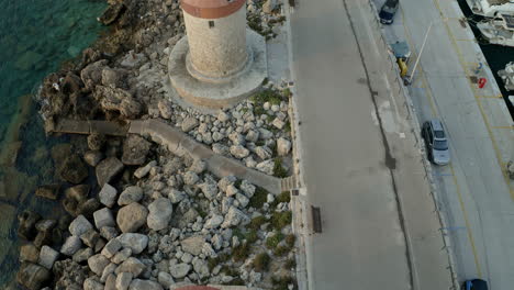 Eine-Luftaufnahme-Der-Stadt-Rhodos-In-Griechenland-Mit-Ausschnitten-Der-Mittelalterlichen-Altstadt,-Dem-Alten-Leuchtturm-Am-Hafen,-Alten-Windmühlen,-Stränden-Und-Einem-Atemberaubenden-Sonnenuntergang