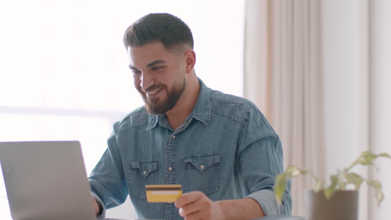 Uomo che usa un laptop e una carta di credito per fare acquisti online