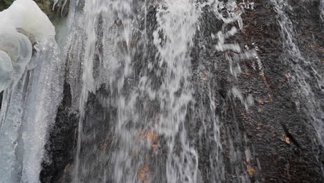 Quellwasser-Fließt-Wasserfall-Mit-Eiszapfen-Im-Winter,-Schieberegler-Erschossen