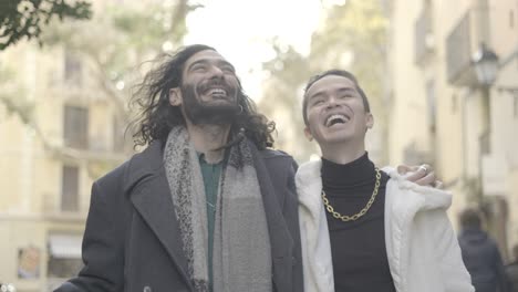 two friends walking and laughing on a city street