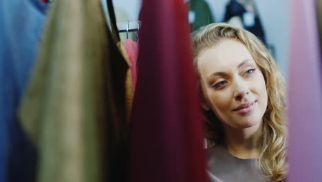 mujer joven elige un vestido en una tienda 2