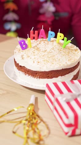 birthday cake with 'happy birthday' candles and gift
