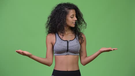young beautiful hispanic woman with gym clothes having decisions