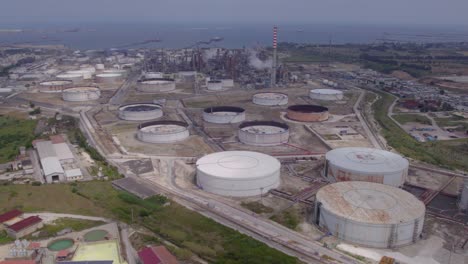 aerial establishing shot of an old empty fuel gas storage facility and oil refinery in catania, sicily, italy