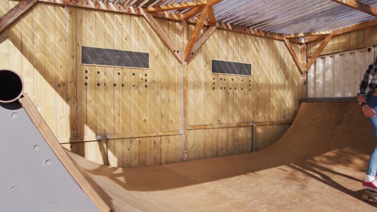 video de una feliz patinadora caucásica entrenando en un parque de patinaje