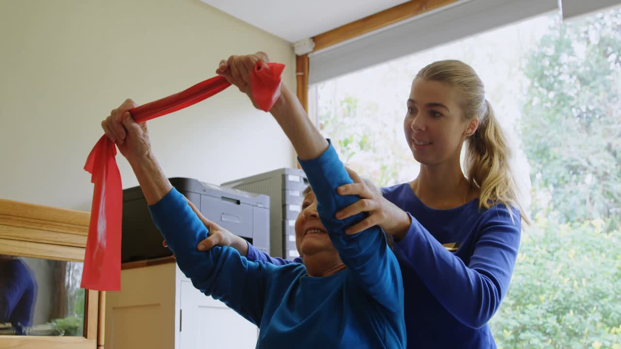 fisioterapeuta corrigiendo la posición de una mujer mayor 4k