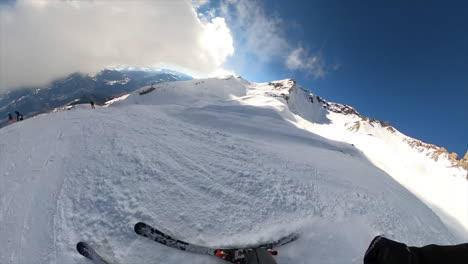 A-young-skier-makes-a-small-jump-in-swiss-alps-snow-slopes,-360-GoPro-film