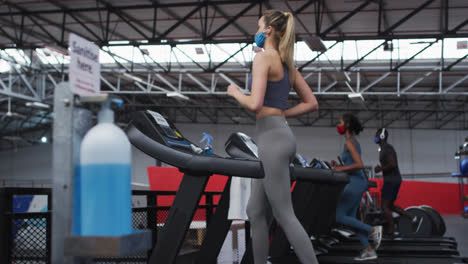 View-of-sanitizer-foot-dispenser-stand-while-two-caucasian-fit-women-and-fit-african-american-man-we