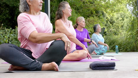 diverse group of women practicing yoga outdoors, focused and serene