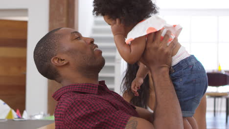 parents playing with young daughter at home