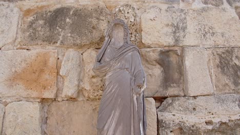 estatua de jesús cerca de la antigua muralla histórica de piedra caliza en la ciudad de salamis, chipre