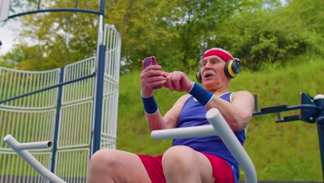 senior woman after sport training listening music on playground, celebrate win doing winner gesture