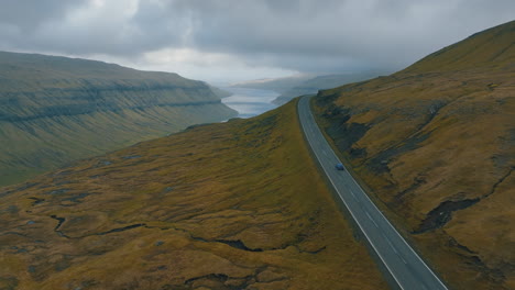 Recorrido-Panorámico:-Cinematografía-Aérea-De-Un-Automóvil-Moviéndose-A-Través-Del-Espectacular-Paisaje-De-Las-Islas-Feroe-Con-Drones