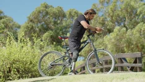 side view of biker with disability using mobile phone