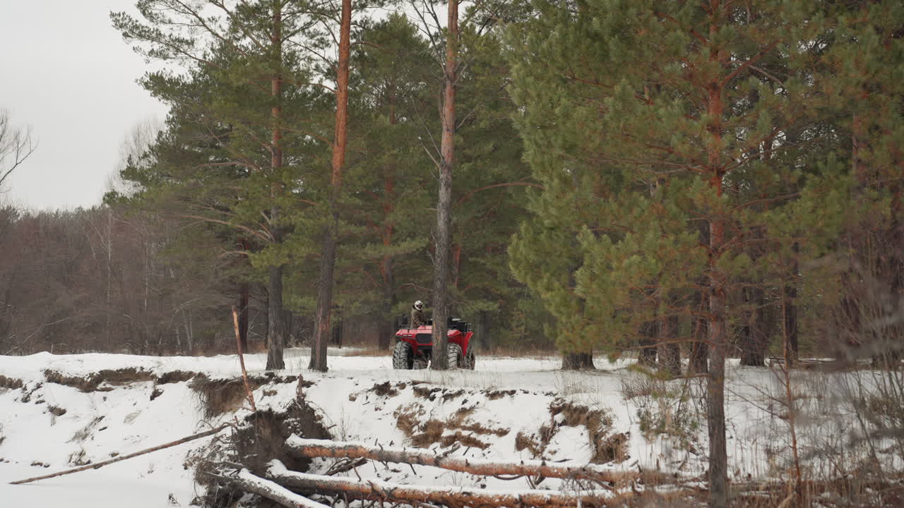 Conducente di quad rosso in una foresta innevata, un pilota agile che sfreccia nella neve fresca con un'improvvisa esplosione di velocità, spruzzi di neve, uno stretto corridoio di pini, manovre estreme, atmosfera carica di adrenalina, sport d'azione.