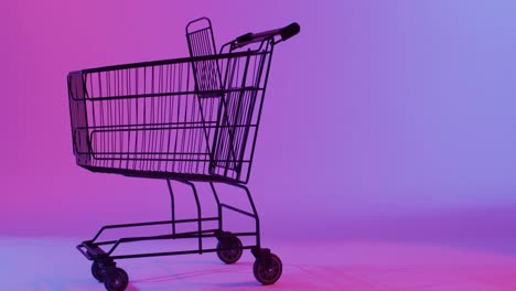 video of shopping trolley with copy space over neon purple background