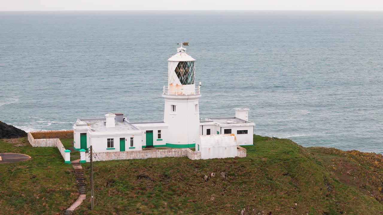 Strumble head lighthouse tower beacon flashing across rugged Pembrokeshire coastal mainland