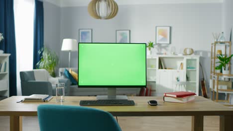 modern personal computer with mock-up green screen display standing on the desk of the cozy home office. living room created by interior designer with good taste and style.