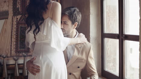 couple in intimate moment by a window