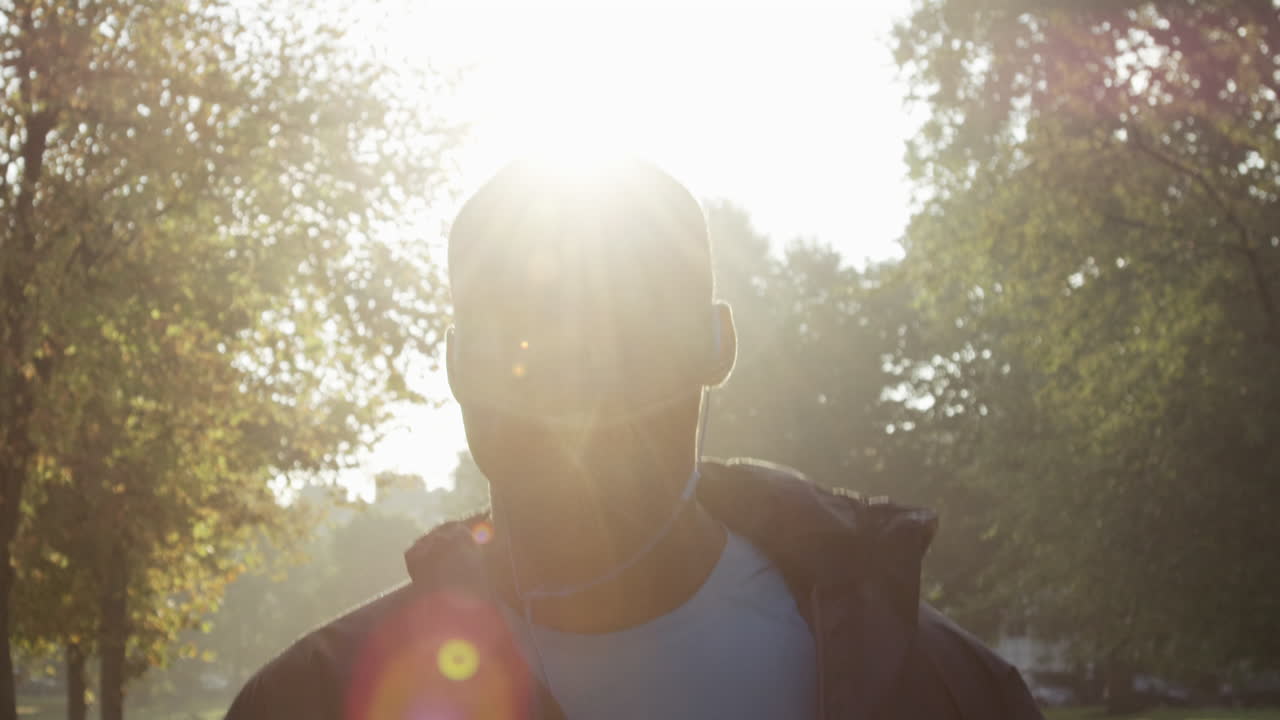Runner man running in park exercising outdoors fitness tracker wearable technology