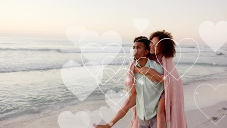 animation of hearts moving over biracial man carrying woman piggyback on beach in summer