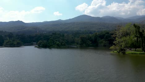drone aéreo ascendente sobre el lago con montañas en la distancia en movimiento lento