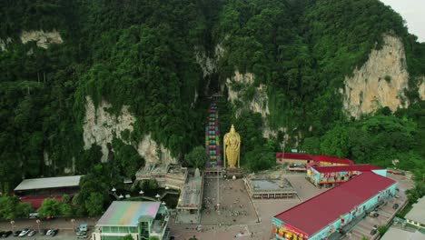 aerial image of the famous batu caves, featuring the cathedral cave with the golden statue of murugan and the colorful staircase, located near kuala lumpur, malaysia.