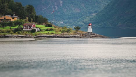 lighthouse, cabins, and houses on the roky shore of the hardanger fjord