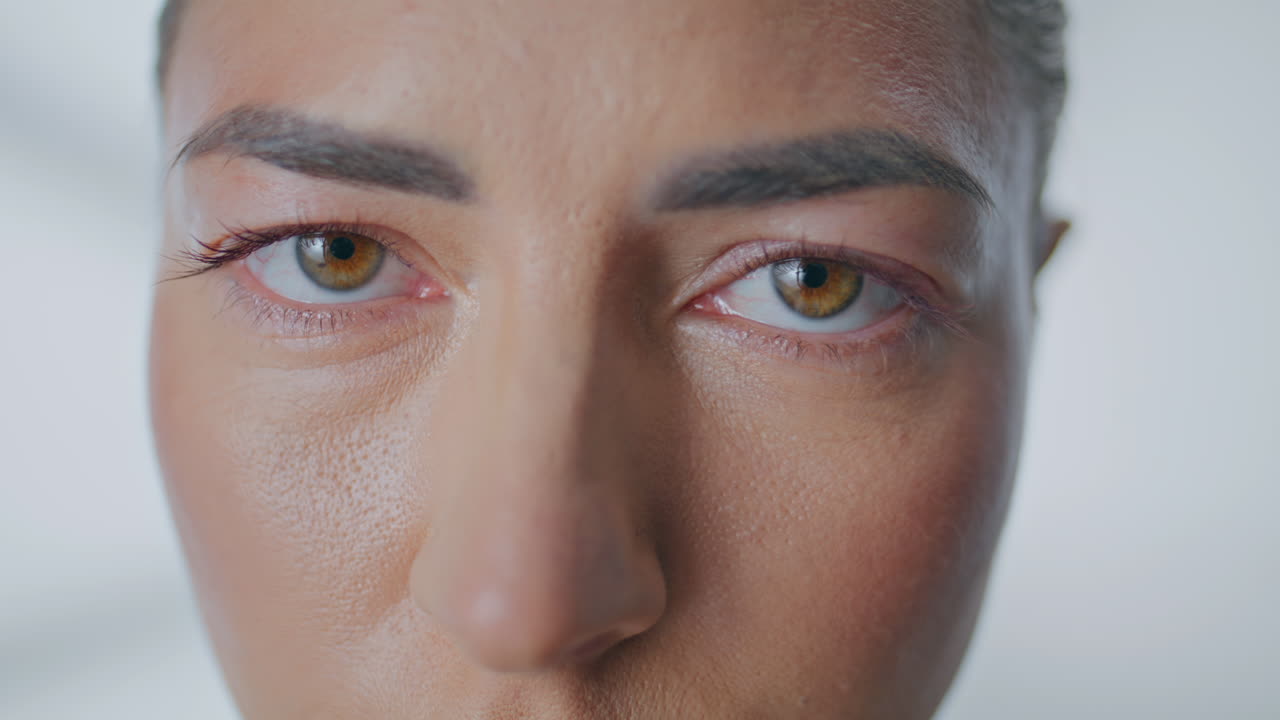 Serene woman eyes looking camera in sunlight closeup. Portrait girl staring