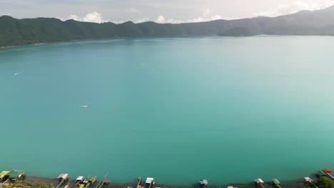 Aerial-pan-shot-of-the-volcanic-lake-of-Coatepeque-in-El-Salvador-with-teal-water