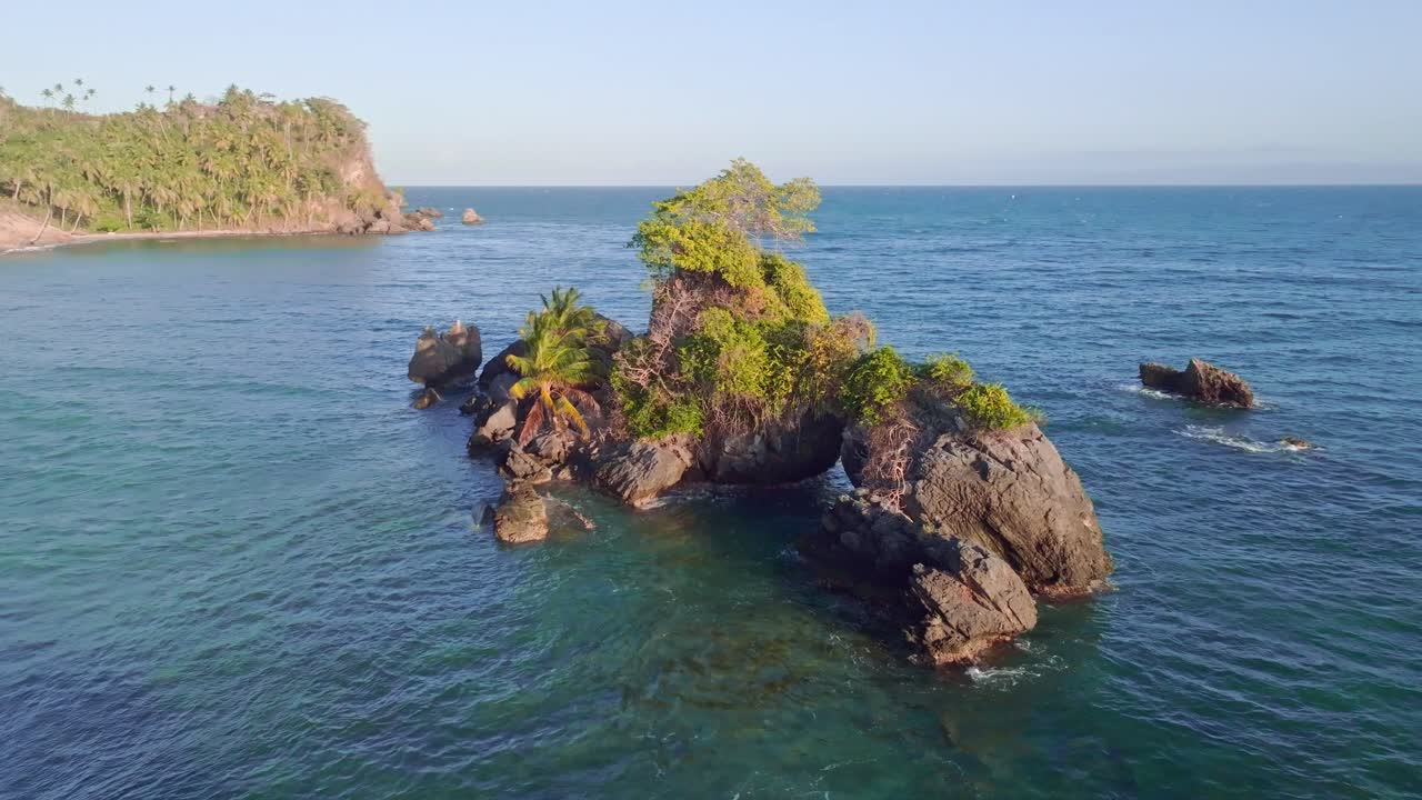 vista aérea de las rocas en el mar del caribe con palmeras en crecimiento durante la puesta de sol dorada - punta balandra, samana