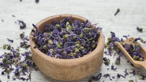 dried purple flowers in wooden bowl