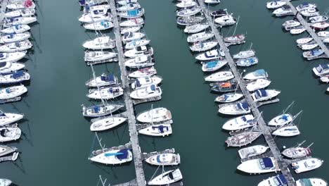 Luftaufnahme-Von-Oben-Nach-Unten-über-Luxusyachten,-Die-Am-Türkisfarbenen-Meerwasserhafen-Geparkt-Sind