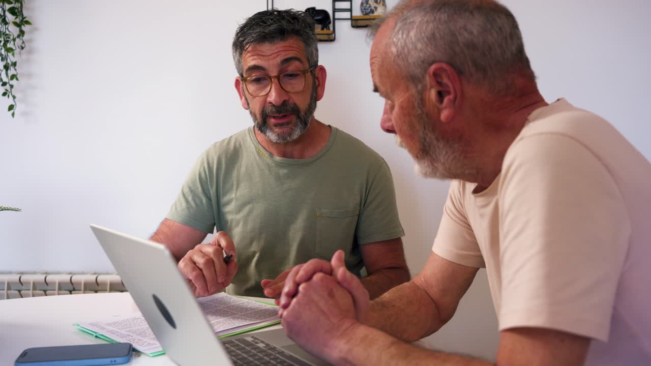Due uomini che collaborano per affari con laptop e documenti