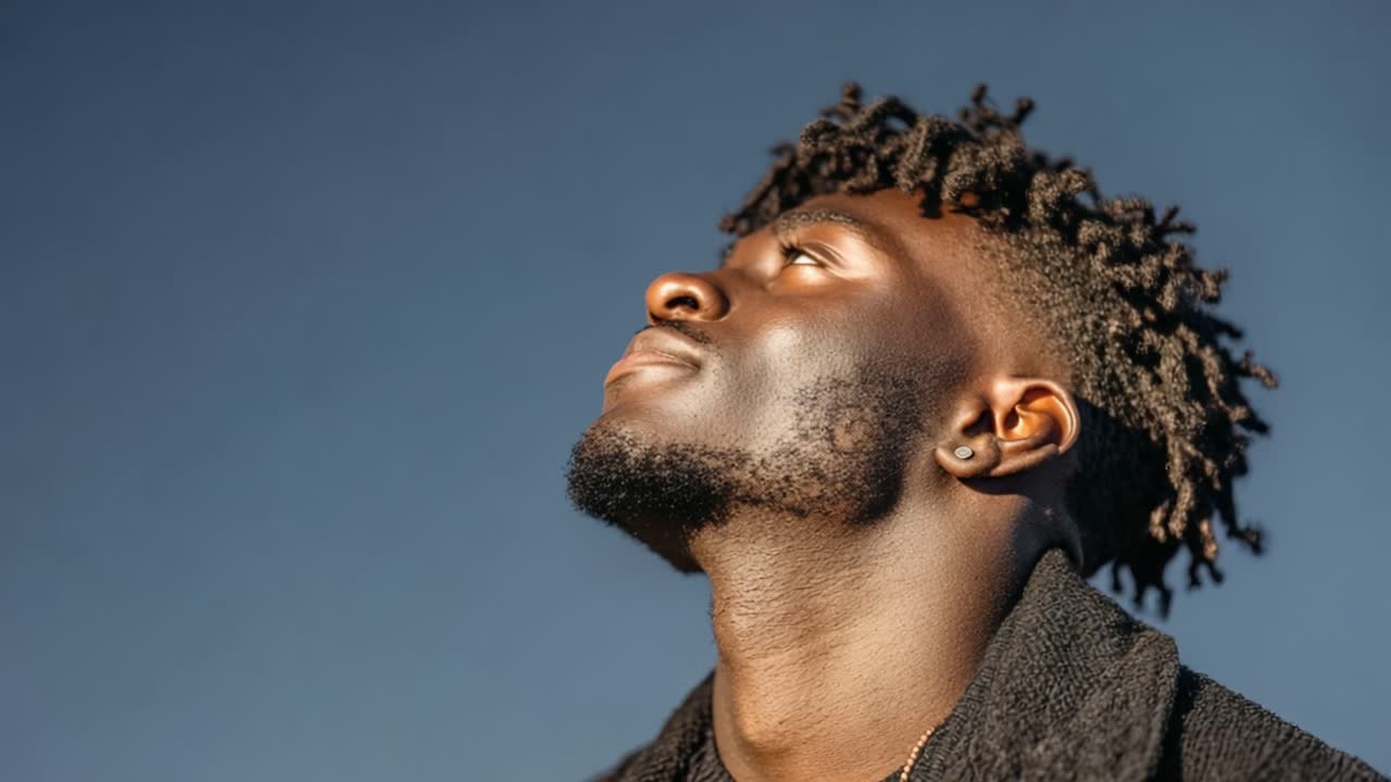 A Man Exudes Serenity and Joy While Gazing Upwards Against a Clear Blue Sky, Symbolizing Reflection, Hope, and Inner Peace in Nature's Embrace