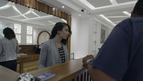 female receptionist talking to the guests at the hotel front desk